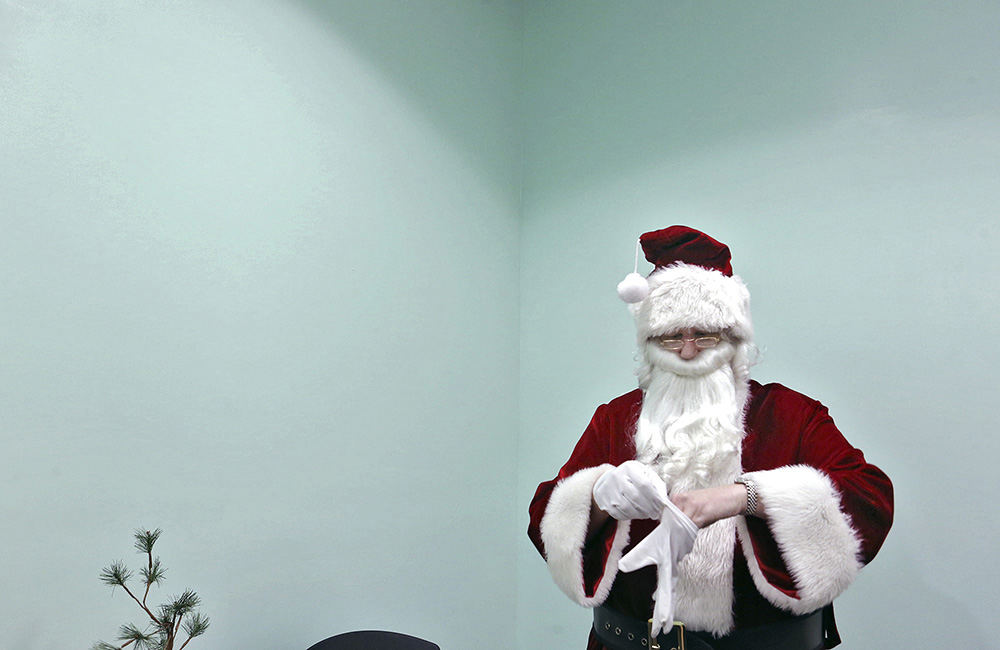 MT Story - 1st place   - Mental Health Advocate Gabe Howard  dressed as Santa pulls on his gloves before greeting  visitors at the east side PEER Center (Peer’s Enriching Each others’ Recovery). Howard who has a bipolar disorder volunteers his Santa character at mental health clinics like the PEER Center that do not always get a lot of attention at the holidays. (Eric Albrecht / The Columbus Dispatch)